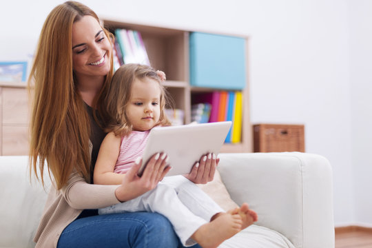 Mother with baby using digital tablet at home