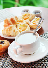 Fresh muffins and tea with milk, breakfast on the veranda