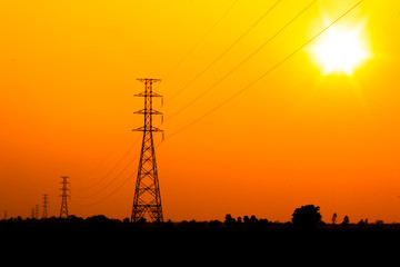 Fototapeta premium High voltage power pole middle of a cornfield with orange sky