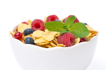 bowl of cornflakes with fresh berries and mint, close-up