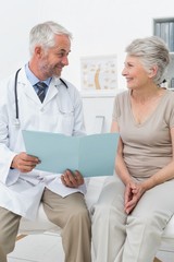 Male doctor and senior patient with reports