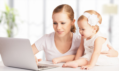 mother and baby at home using laptop computer