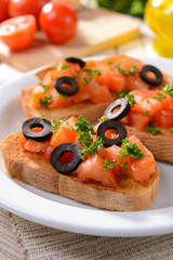 Delicious bruschetta with tomatoes on plate on table close-up