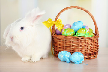 White cute rabbit and Easter eggs in basket