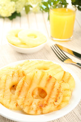 Juicy grilled pineapple on plate on table close-up