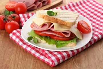 Tasty sandwich with ham on wooden table