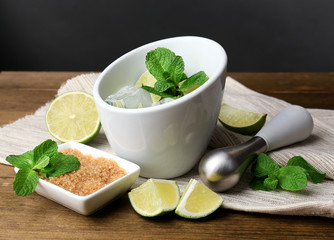 Ingredients for lemonade on wooden table, on grey background