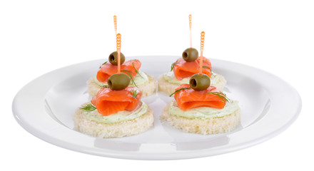 Delicious canapes on plate isolated on white