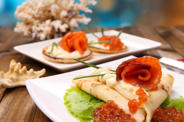 Pancakes with red caviar, salmon and mayo, green onion,