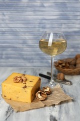 Tasty Italian cheese and glass of vine on wooden table