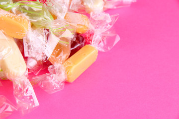 Tasty candies on pink background