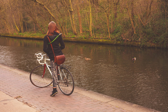 Woman on bicycle by canal