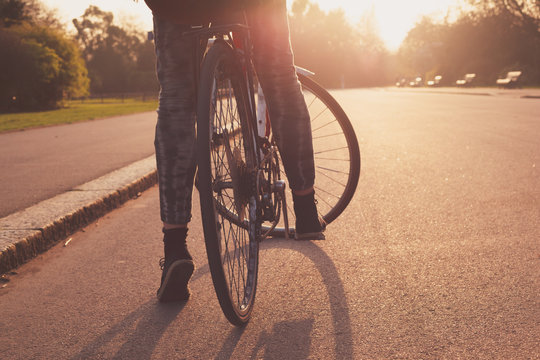 Young woman cycling in the park at sunset