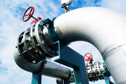 Industrial zone, Steel pipelines and valves against blue sky
