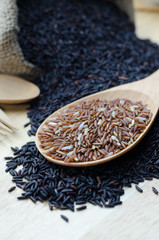 Red jasmine rice and rice berry on wood ladle