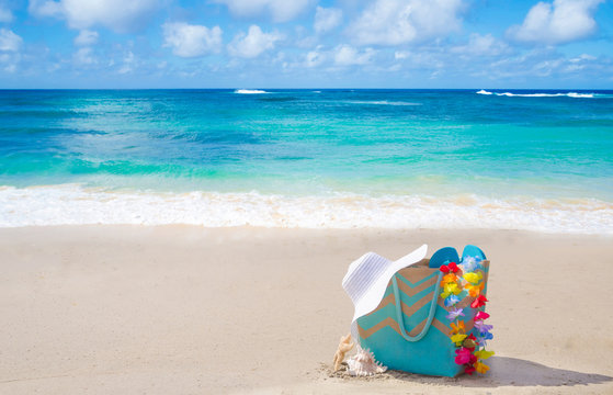 Fototapeta Beach bag with flip flops by the ocean