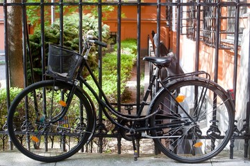 black bike is leaned against fence