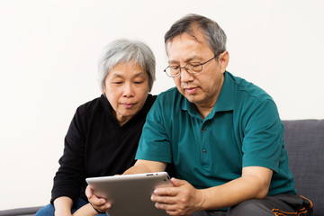 Asian old couple reading on tablet