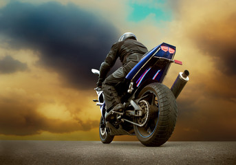 Man seat on the motorcycle under sky with clouds