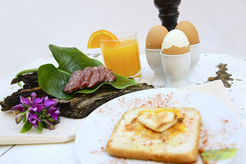 Breakfast with sausage , toast with egg, orange juice