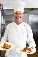 Sonfident male chef with cooked food in kitchen