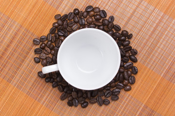 coffee bean around empty coffee cup