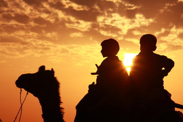 Naklejka premium Boys sit on camel