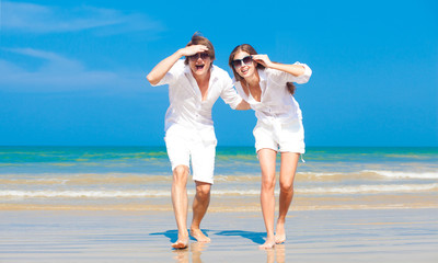 Front view of young couple in white  at the sea