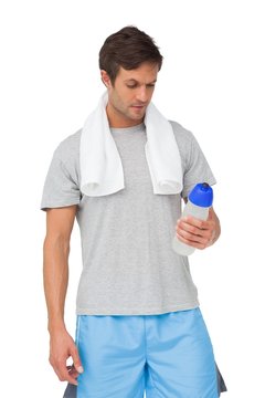 Fit young man with water bottle and towel