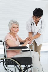 Obraz premium Doctor talking to a senior patient in wheelchair