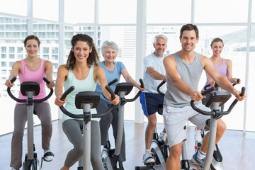 Fototapeta na wymiar Happy people working out at spinning class