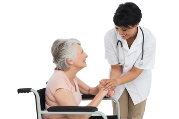 Obraz premium Female doctor talking to a senior patient in wheelchair