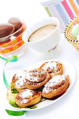 Buns with cinnamon and coffee on white