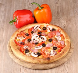 Aromatic pizza with vegetables on wooden background