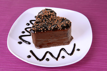 Sweet cake with chocolate on plate on table close-up