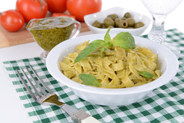 Delicious pasta with pesto on plate on table close-up