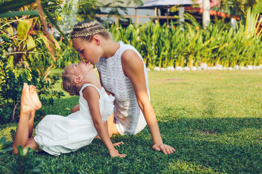 Mother kissing her daughter in the garden