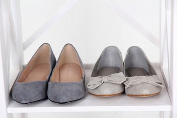 Beautiful female shoes on wooden shelf