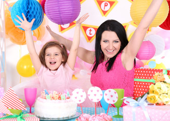 Pretty little girl with mom celebrate her birthday