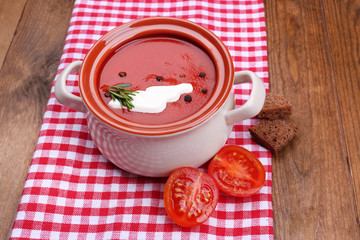 Tasty tomato soup on wooden table