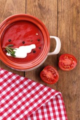 Tasty tomato soup on wooden table