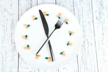 Medication schedule and meals. Conceptual photo. On wooden