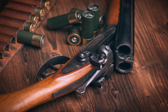 Shotgun with shells on wooden background