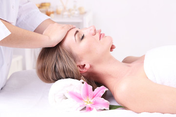 Obraz na płótnie Canvas Beautiful young woman having head massage in spa salon,