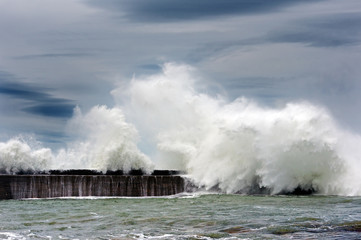 big waves breaking on breakwater