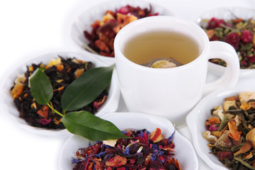 Cup of tea with aromatic dry tea in bowls close up