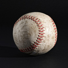 Leather baseball on black with stitching detail