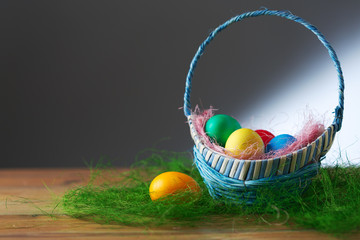 Easter eggs in a basket on a wooden table.
