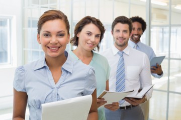 Fototapeta premium Business colleagues holding notepads in row at office