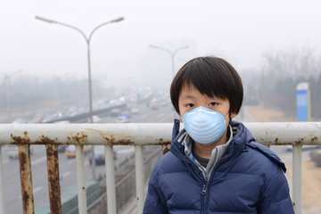 Asian boy wearing mouth mask against air pollution (Beijing) - 62531577